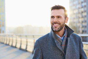 A man smiles, showing off the work of dental implants services 