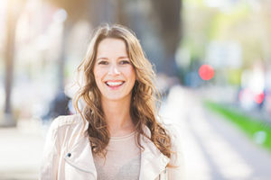 A woman smiles while thinking about general dentistry in Sharpstown TX