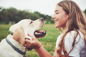 A girl plays with her dog and smiles after she has a teeth cleaning in Sharpstown, TX