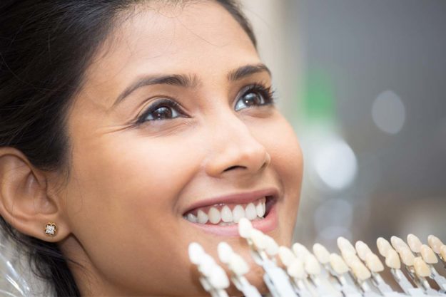dental-veneers-pros-and-cons patient learning about dental veneers