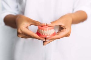 dentist holding a full pair of dentures