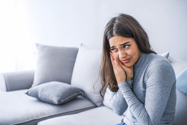 a woman with her mouth hurting from Signs of a cavity