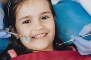 a little girl is happy to be receiving pediatric dentistry care